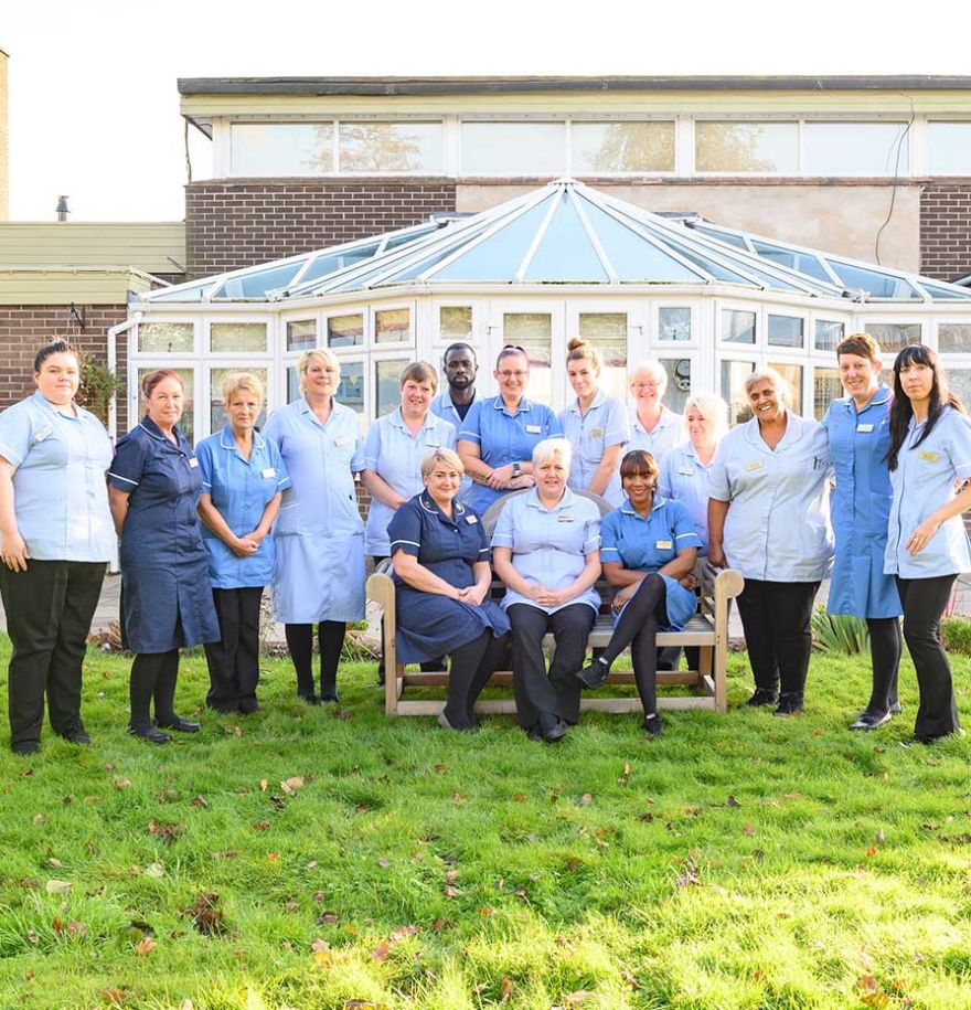 Members of staff pictured together outside in front of the conservatory.
