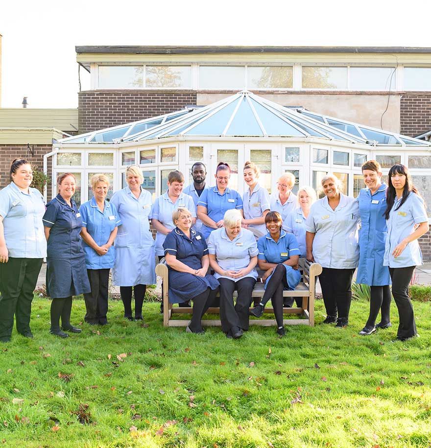 The staff team pictured outside in front of the conservatory together.
